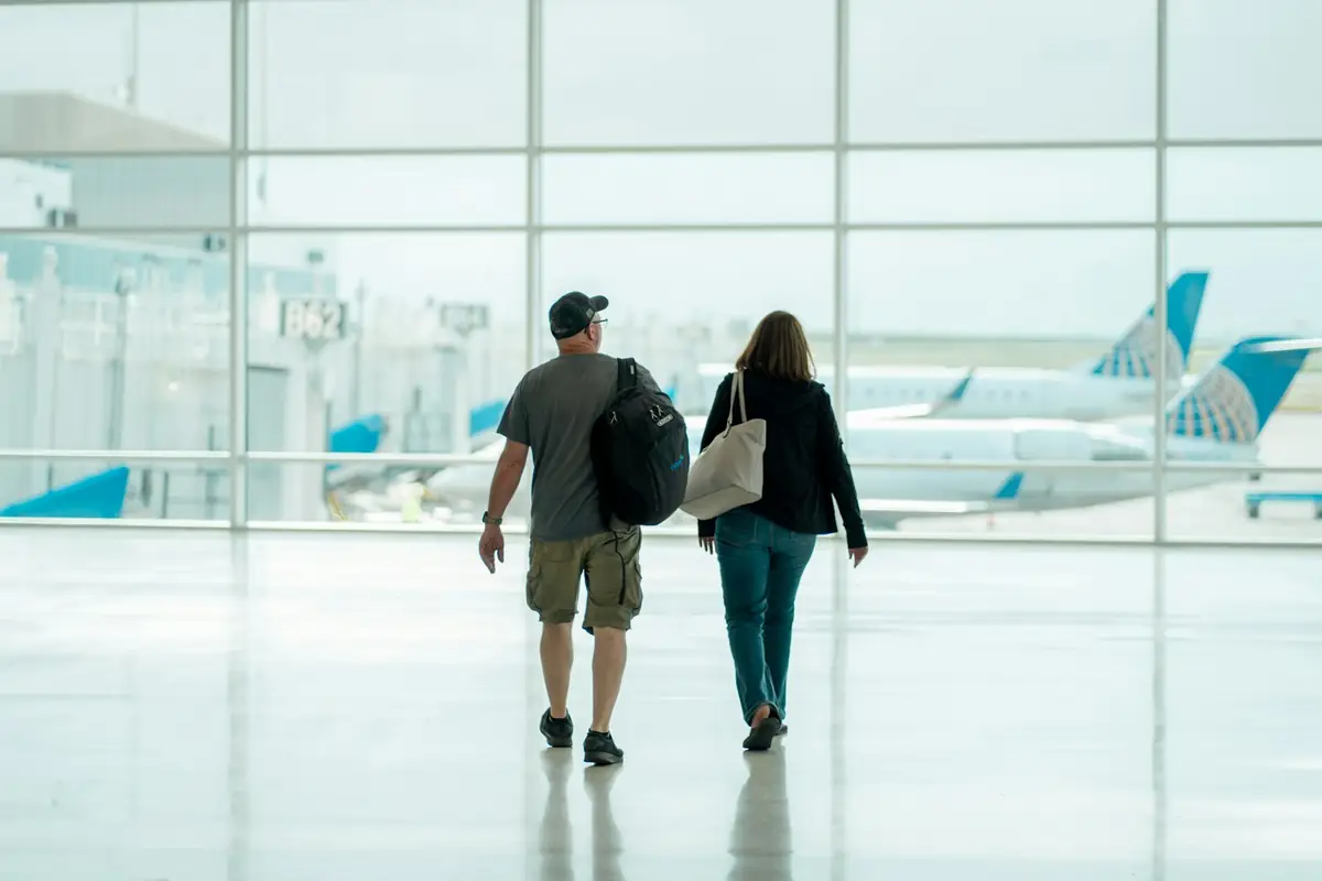 Pareja de viajeros caminando por un aeropuerto