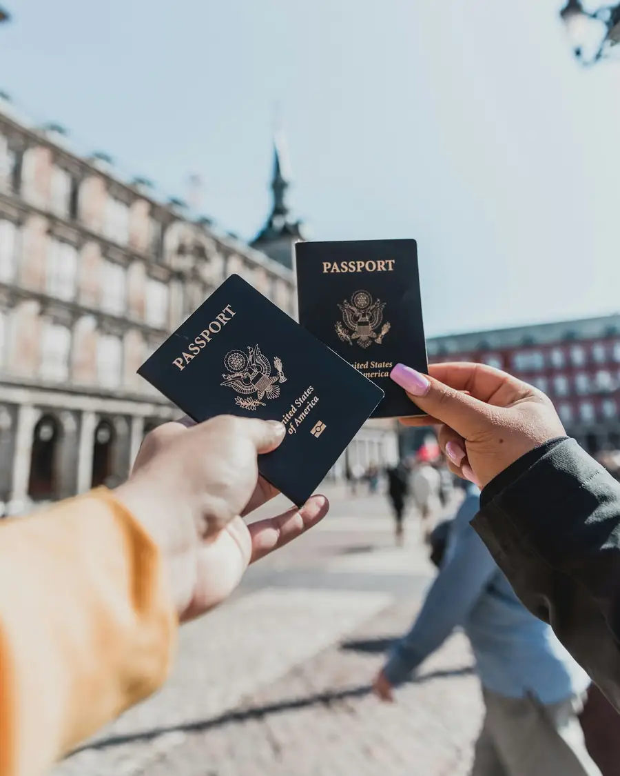 Pasaportes en la mano de dos viajeros