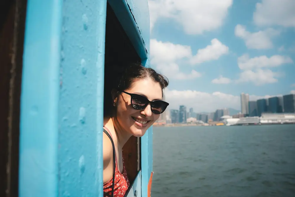 Viajera sonriente asomada a la ventana de un barco